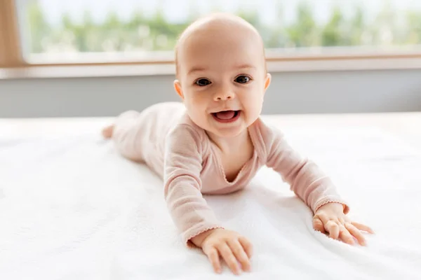 Sweet baby girl lying on white blanket — стоковое фото