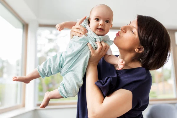 Medelålders mamma som innehar baby dotter hemma — Stockfoto