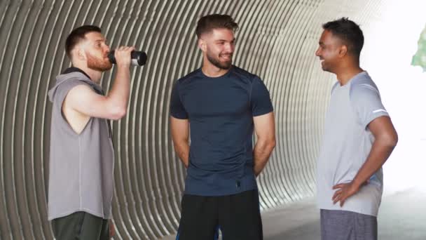 Jóvenes deportistas o amigos varones hablando al aire libre — Vídeo de stock