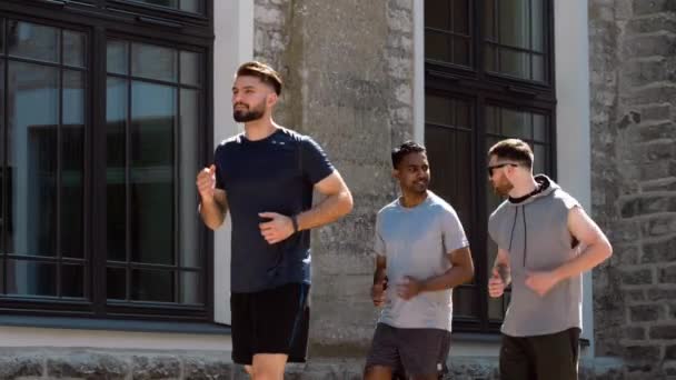 Young men or male friends running outdoors — Stock Video
