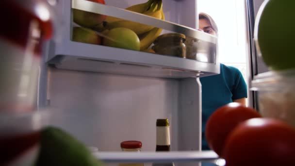 Γυναίκα που παίρνει φαγητό από το ψυγείο στο σπίτι κουζίνα — Αρχείο Βίντεο