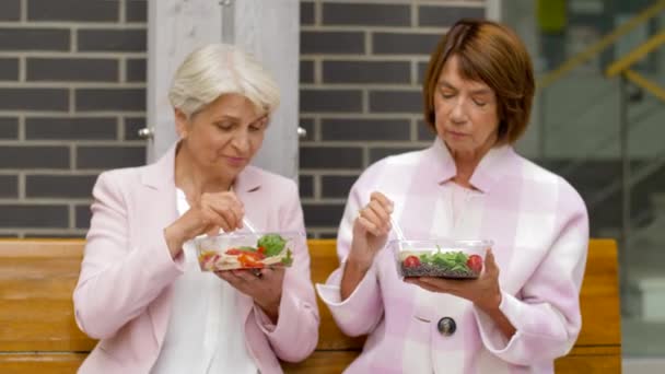 Senior vrouwen eten afhaalmaaltijden op City Street — Stockvideo