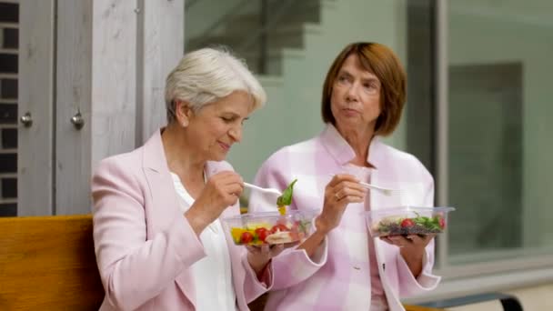 Seniorinnen essen Essen zum Mitnehmen auf der Straße — Stockvideo