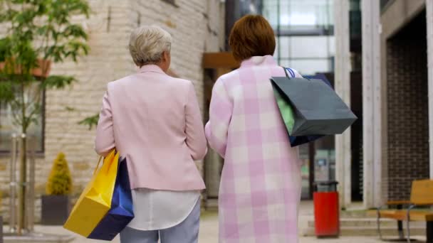 Seniorinnen mit Einkaufstüten spazieren durch die Stadt — Stockvideo