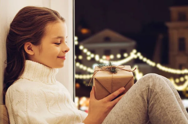 Chica con regalo de Navidad sentado en la ventana —  Fotos de Stock