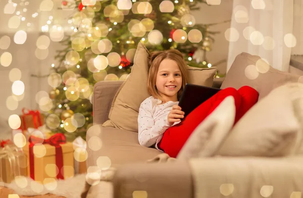 Chica sonriente con la tableta de la PC en casa de Navidad —  Fotos de Stock