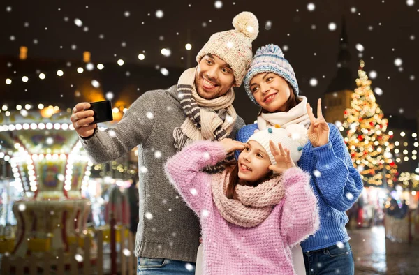 Mutlu aile Noel pazarında selfie çekiyor. — Stok fotoğraf