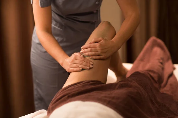 Mujer acostada y teniendo masaje de piernas con gel en el spa —  Fotos de Stock