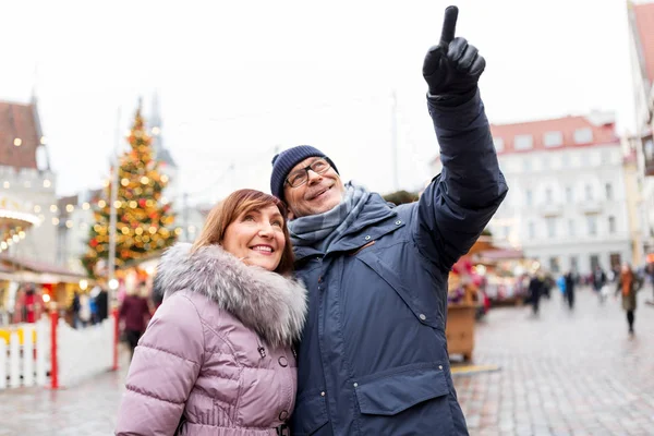 Feliz pareja de ancianos abrazándose en el mercado de Navidad — Foto de Stock