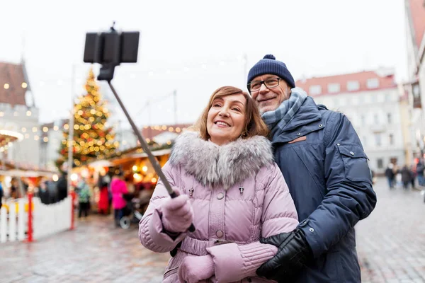 Pareja de ancianos tomando selfie en el mercado de Navidad — Foto de Stock