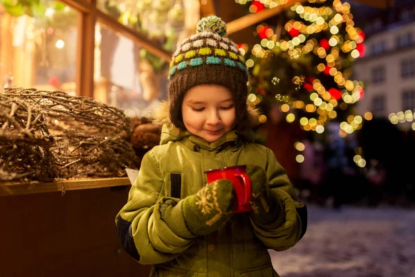 Heureux garçon avec tasse de thé au marché de Noël — Photo