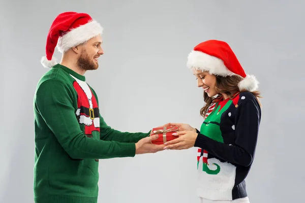 Boldog pár karácsonyi pulóverben ajándékdobozzal Stock Kép