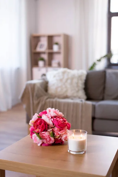 Burning fragrance candle and flower bunch at home — Stock Photo, Image