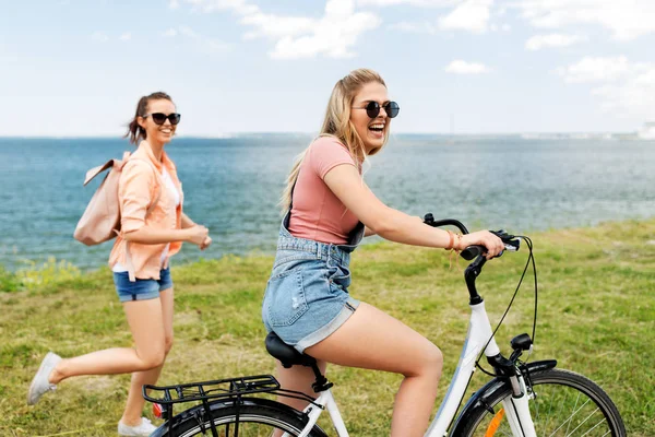 Девушки-подростки или друзья с велосипедом летом — стоковое фото