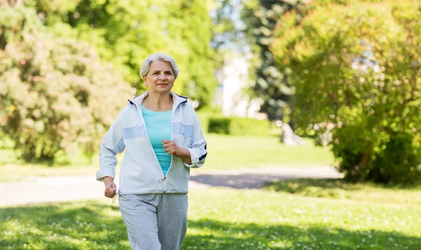 Mujer mayor corriendo a lo largo del parque de verano —  Fotos de Stock