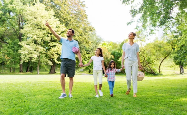 夏の公園をピクニックバスケットで歩く家族 — ストック写真