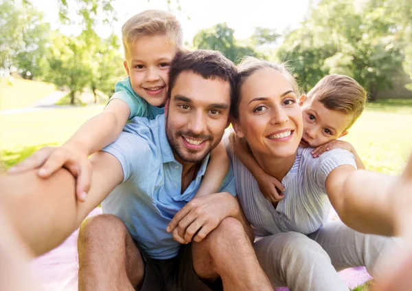 Familj som har picknick och tar selfie i parken — Stockfoto