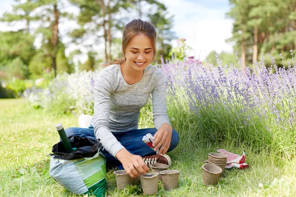 Frau pflanzt Samen in Töpfe im Sommergarten — Stockfoto