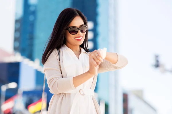 Donna che guarda orologio da polso o orologio intelligente in città — Foto Stock