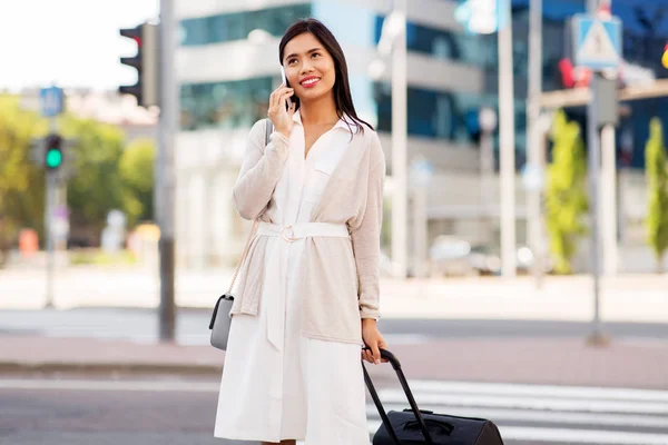 Donna con borsa da viaggio che chiama al cellulare in città — Foto Stock