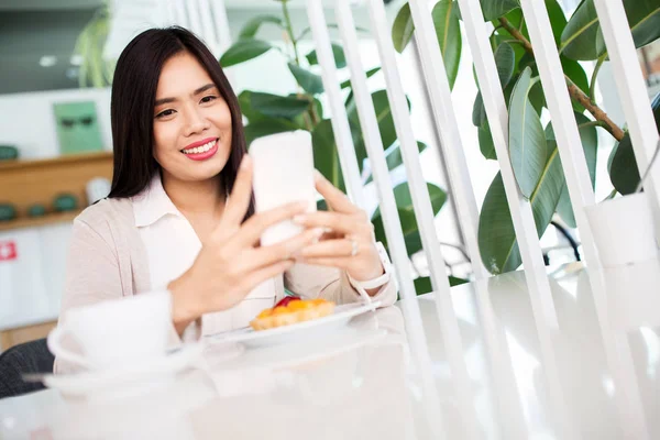 카페 나 커피 숍에서 스마트 폰을 가진 아시아 여자 — 스톡 사진