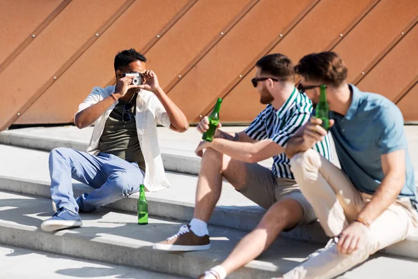 Hombre fotografiando amigos bebiendo cerveza en la calle —  Fotos de Stock