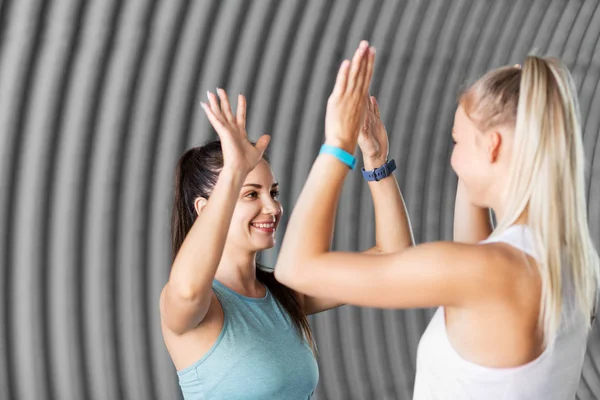 Glückliche Frauen mit Fitness-Trackern machen High Five — Stockfoto