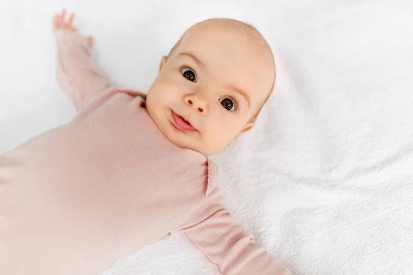 Dolce bambina sdraiata sulla coperta bianca — Foto Stock