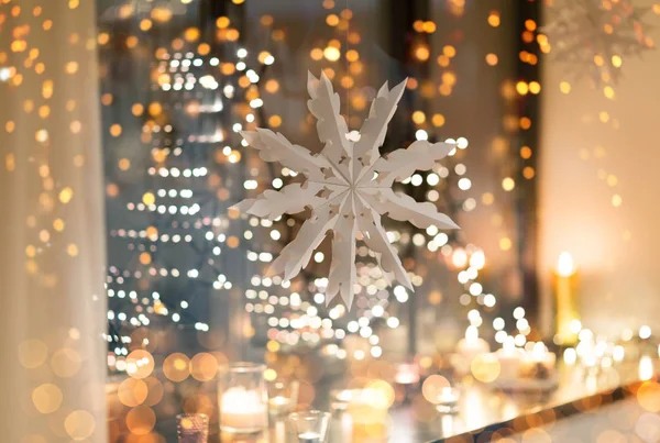 Decoración de copo de nieve de papel colgando en la ventana —  Fotos de Stock