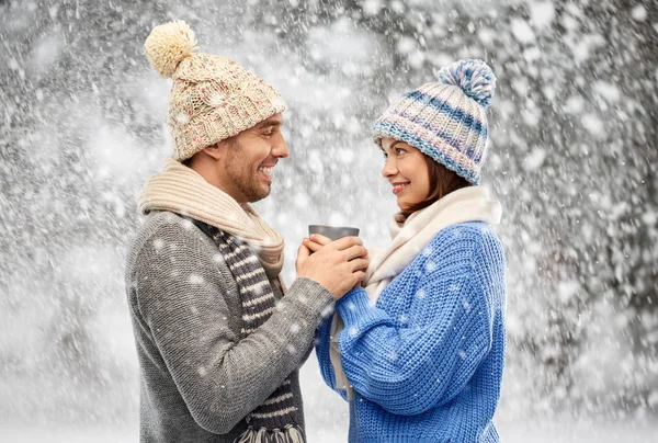 Feliz pareja en ropa de invierno sosteniendo una taza — Foto de Stock