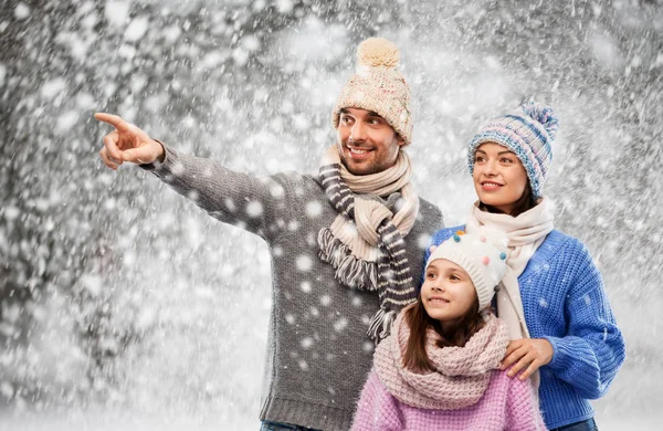 Familia feliz en ropa de invierno sobre fondo de nieve —  Fotos de Stock