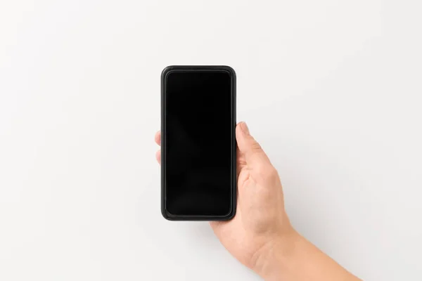 Primer plano de la mano con el teléfono inteligente negro — Foto de Stock