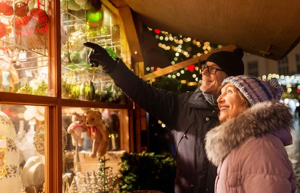 Heureux couple de personnes âgées étreignant au marché de Noël — Photo