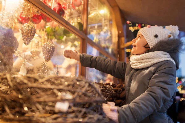 Дівчина вибирає різдвяні прикраси на ринку — стокове фото