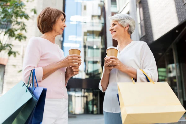 Mulheres idosas com sacos de compras e café na cidade — Fotografia de Stock