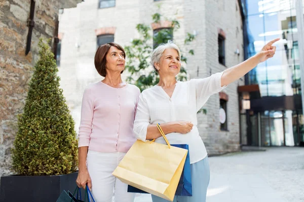 Mulheres idosas com sacos de compras andando na cidade — Fotografia de Stock