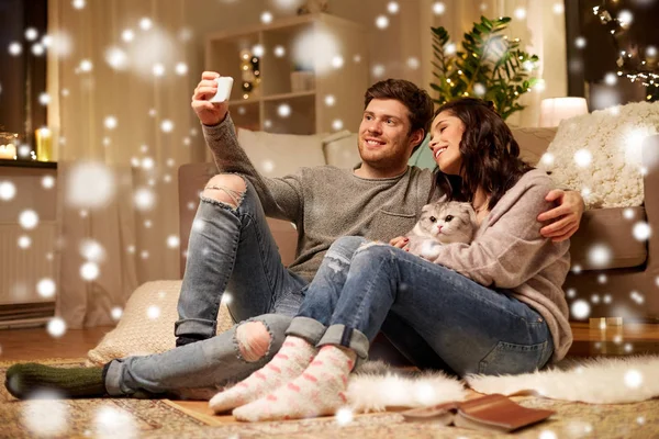 Счастливая пара делает селфи на смартфоне дома — стоковое фото