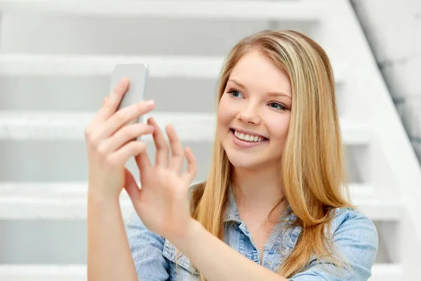 Девочка-подросток делает селфи на смартфоне на лестнице — стоковое фото