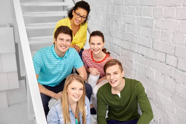 Amigos adolescentes ou estudantes pendurados nas escadas — Fotografia de Stock