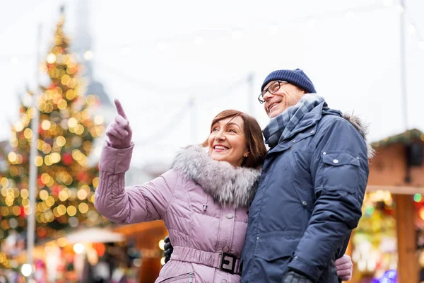 Glückliches Senioren-Paar umarmt sich auf Weihnachtsmarkt — Stockfoto