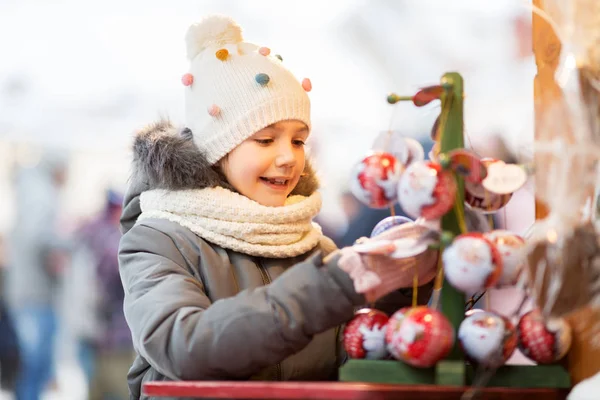 Petite fille choisir boules de Noël au marché — Photo