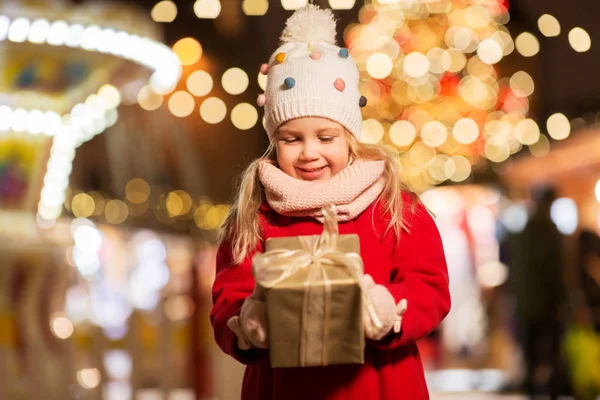 Fille heureuse avec boîte cadeau au marché de Noël — Photo