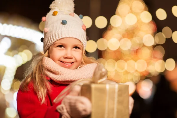 Lycklig tjej med presentförpackning på julmarknad — Stockfoto