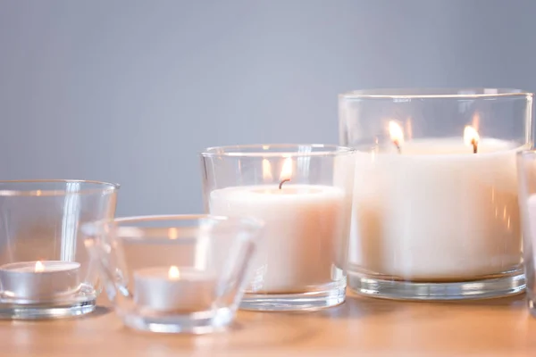 Burning white fragrance candles on wooden table — Stock Photo, Image