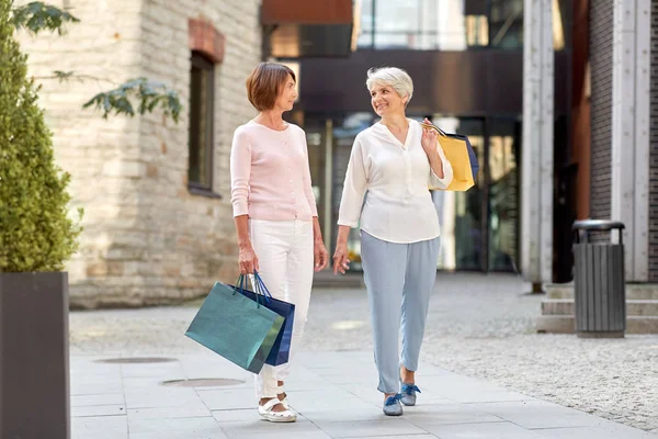 Senior vrouwen met boodschappentassen wandelen in de stad — Stockfoto