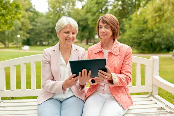 Mujeres mayores con tableta PC en el parque de verano —  Fotos de Stock