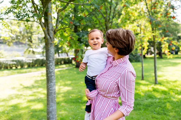 Lycklig mor med liten son i sommarparken — Stockfoto