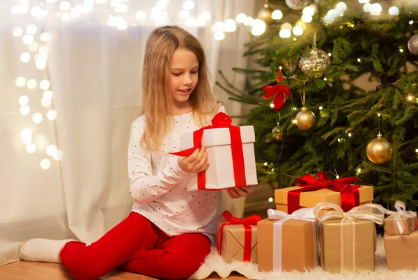 Leende flicka med julklapp hemma — Stockfoto