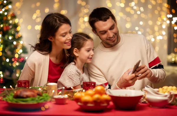 Rodzina ze smartfonem o kolacji świątecznej — Zdjęcie stockowe