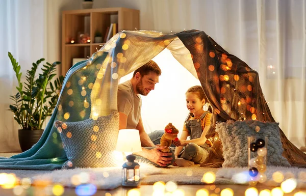 Famiglia felice che gioca con il giocattolo nella tenda dei bambini a casa — Foto Stock